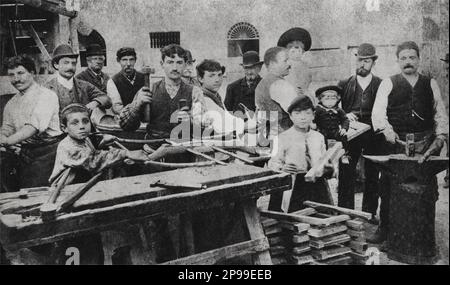 1893 , Roma : le jeune acteur et scénariste italien ETTORE PETROLINI ( Roma 1886 - 1936 ) quand était un jeune garçon ( le garçon avec du bois , droit dans cette photo ) dans l'usine du grand-père Salvatore Antonelli Pétrolini , Un menuisier - TEATRO - THEATRE - THÉÂTRE - attore teatrale - drammaturgo - bpy - enfant - enfants au travail - bambini - COMICO - personalita' da giovani giovane - personnalité quand était jeune --- Archivio GBB Banque D'Images