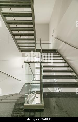 Escaliers métalliques d'un immeuble de bureaux avec marches et atterrissages en granit noir poli Banque D'Images