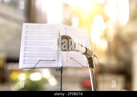 Concept avec fond musical d'interprétation de chansons religieuses avec microphone et stand de musique dans l'église. Vue avant. Banque D'Images