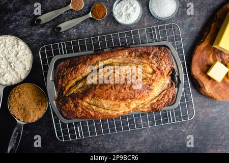 Pain de banane fraîchement cuit dans un moule à pain : pain de banane dans un moule antiadhésif sur une grille de refroidissement Banque D'Images