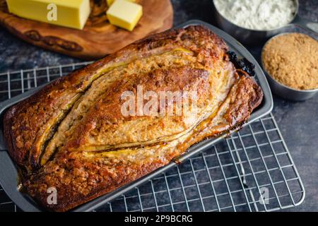 Pain de banane fraîchement cuit dans un moule à pain : pain de banane dans un moule antiadhésif sur une grille de refroidissement Banque D'Images