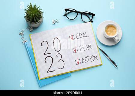 Composition d'un bloc-notes avec texte 2023 objectif, plan, action sur fond bleu clair. Objectifs de la nouvelle année Banque D'Images