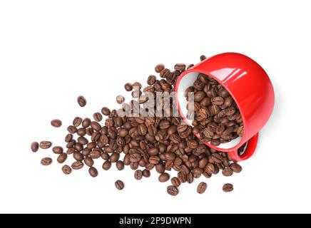 Tasse retournée avec grains de café rôtis sur fond blanc, vue du dessus Banque D'Images