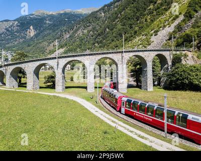 Brusio, Suisse: 26 août 2018 - Bernina Express traverse le célèbre viaduc circulaire dans la montagne des Alpes suisses, le canton des Grisons, cette spirale Banque D'Images