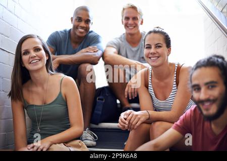 Détendez-vous dans l'escalier avant la classe. étudiants de l'université assis sur les marches d'un escalier. Banque D'Images