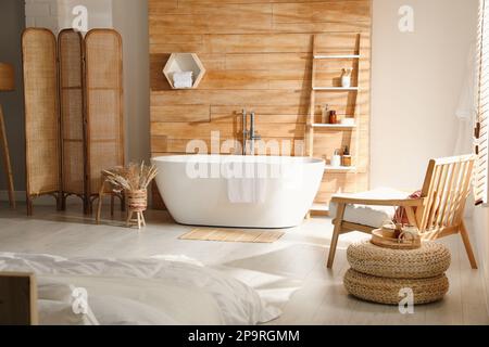 Intérieur élégant de l'appartement avec baignoire et lit blancs Banque D'Images