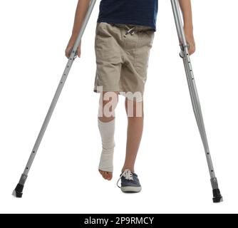 Garçon avec jambe blessée utilisant des béquilles sur fond blanc, gros plan Banque D'Images