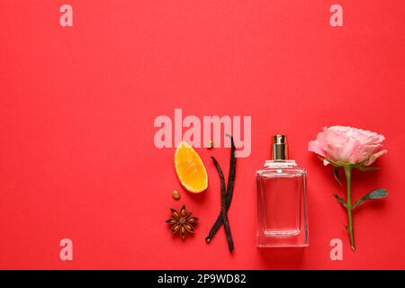 Composition de la couche plate avec bouteille de parfum et agrumes frais sur fond rouge. Espace pour le texte Banque D'Images