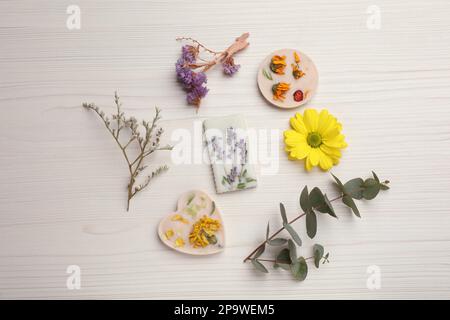 Beaux sachets parfumés et fleurs sur une table en bois blanc Banque D'Images