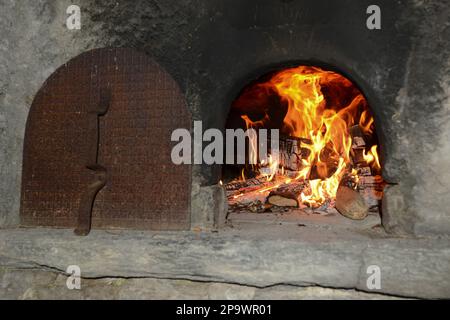 Staycation, feu de bois dans four traditionnel, four en pierre Banque D'Images