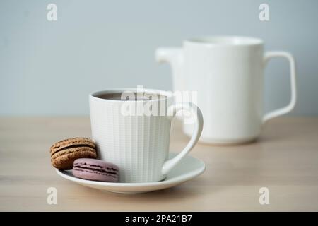 Temps de thé. Tasse de thé avec théière et macaron. Banque D'Images