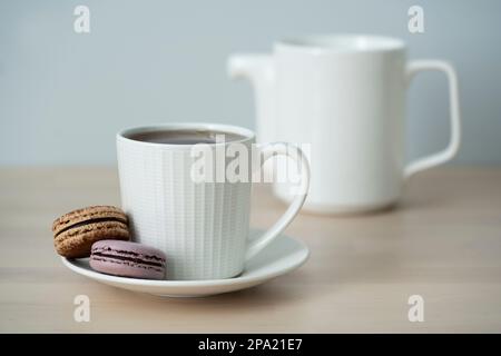 Temps de thé. Tasse de thé avec théière et macaron. Banque D'Images