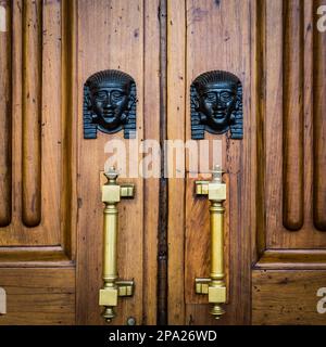 Détail de deux têtes de Sphinx en bronze sur une vieille porte en bois - autour de 100 ans, palais italien dans le Nord de l'Italie Banque D'Images