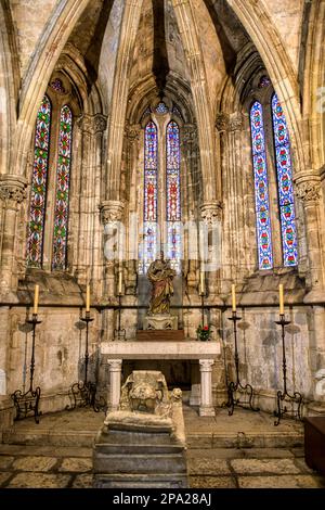 Trois vitraux dans une chapelle voûtée en pierre. Détail de l'architecture à l'intérieur du célèbre monument catholique. Banque D'Images