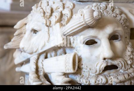 Ancien masque de théâtre, en marbre, situé à la base d'une colonne romaine à Rome - Italie Banque D'Images