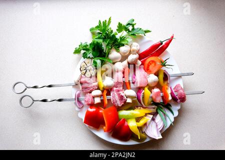 Brochettes de viande crues. Griller de la viande avec des légumes et des épices sur fond de pierre. Espace libre pour le texte brochettes de kebab brut sur une planche à découper avec des légumes et des épices sur fond rustique en bois Banque D'Images