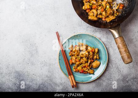 Vue de dessus du poulet Kung Pao sur l'assiette prête à manger, espace pour le texte. Plat traditionnel chinois sauté avec poulet, arachides, légumes et piment Banque D'Images