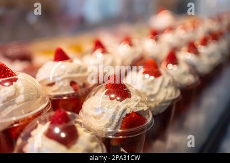 Fraises à la crème préparées dans des récipients pour la consommation individuelle et exposées à la vente, Mercado de San Miguel, Madrid. Banque D'Images