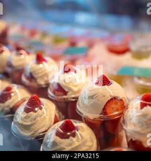 Fraises à la crème préparées dans des récipients pour la consommation individuelle et exposées à la vente, Mercado de San Miguel, Madrid. Banque D'Images