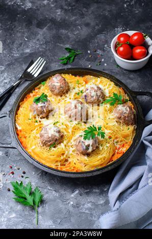 Les pâtes se nichent avec des boulettes de viande et de la sauce tomate sur une assiette, des pâtes fraîchement cuites, de la nourriture savoureuse, un fond sombre Banque D'Images