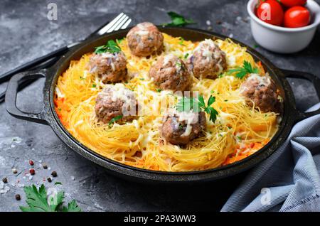 Les pâtes se nichent avec des boulettes de viande et de la sauce tomate sur une assiette, des pâtes fraîchement cuites, de la nourriture savoureuse, un fond sombre Banque D'Images