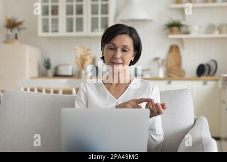 Positive senior professeur en ligne femme donnant en ligne atelier Banque D'Images