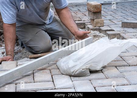 Brésilien et travailleur de la construction utilisant une règle pour vérifier le niveau des blocs de béton. Banque D'Images