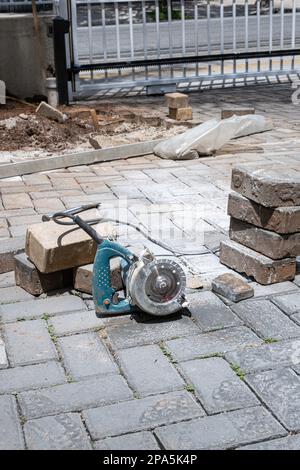 Petite scie de béton à côté de blocs de pierre sur un jour ensoleillé vertical. Banque D'Images