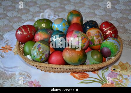 Gros plan d'un panier tissé avec des œufs teints multicolores pour la fête traditionnelle de Pâques en Bulgarie en avril. Image horizontale, mise au point sélective Banque D'Images