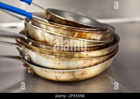 Pile de sale, usé des marmites d'aluminium dans une cuisine de restaurant Banque D'Images