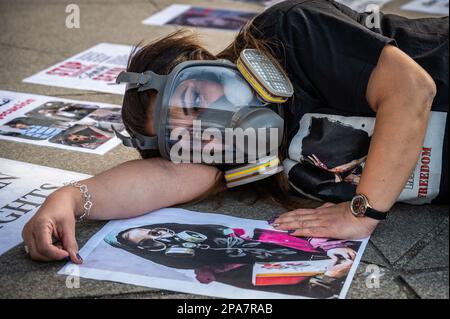 Madrid, Espagne. 11th mars 2023. Une femme portant un masque à gaz couché sur le sol est vue lors d'une manifestation où la communauté iranienne de Madrid manifeste contre les centaines de jeunes filles empoisonnées en Iran dans une tentative présumée de fermer des écoles depuis novembre dernier. Credit: Marcos del Mazo/Alay Live News Banque D'Images