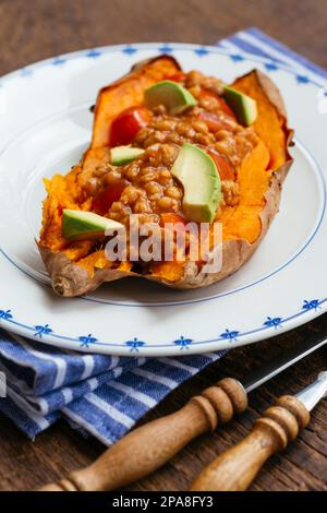 Les patates douces cuites au four avec un chili végétalien. Banque D'Images