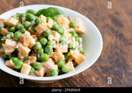 Salade de pois avec des produits laitiers Fromage vegan et morceaux de saucisses. Banque D'Images