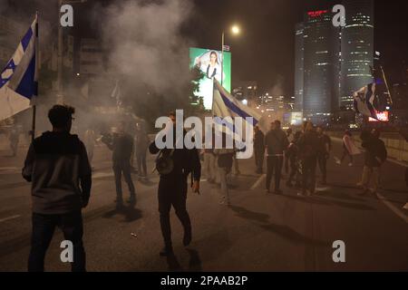 Tel Aviv, Israël. 11th mars 2023. Des manifestants israéliens bloquent la route au cours d'une manifestation contre la réforme du système juridique prévue par le gouvernement. Crédit : Ilia Yefimovich/dpa/Alay Live News Banque D'Images