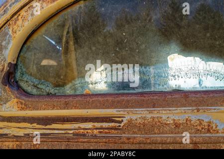 Les motifs dans la vitre de la lunette arrière d'un camion à panneaux rouillés antique Banque D'Images