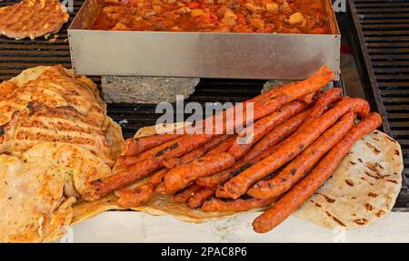 Saucisses de porc grillées et hamburgers au chou cuit en plaque métallique et pain tortilla vendus sur le marché pendant le festival traditionnel Banque D'Images