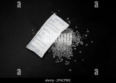 Dessiccant silice Gel cristaux adsorbant sur fond noir vue du dessus, billes de dessiccant polymère, bouchon de silice Banque D'Images