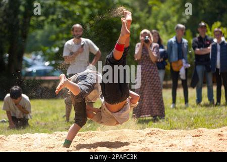 Pleyber-Christ, France - 29 mai 2022 : deux jeunes hommes pratiquant la lutte bretonne (gouren) sur la sciure. Banque D'Images