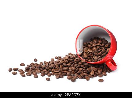 Tasse retournée avec grains de café torréfiés sur fond blanc Banque D'Images