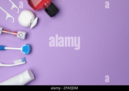 Composition de pose plate avec nettoyant pour langue et produits de soin des dents sur fond violet, espace pour le texte Banque D'Images