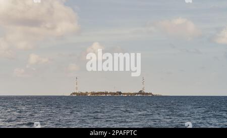 Du point de vue d'un bateau naviguant dans la vaste étendue de la mer, une vue sur une île lointaine. Sur fond d'un ciel magnifique peint à l'intérieur Banque D'Images