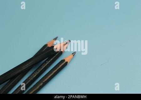 un gros plan d'un tas de crayons isolés sur un fond bleu. concept photo créatif. Banque D'Images
