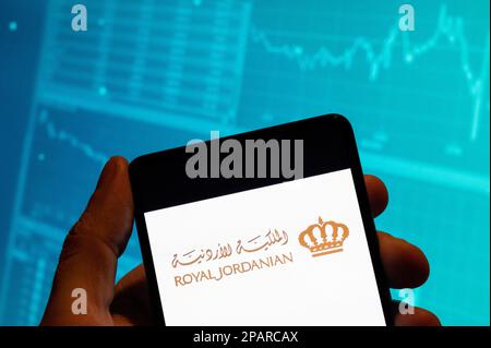 Chine. 19th févr. 2023. Dans cette illustration, le logo de la compagnie aérienne Royal Jordanian est affiché sur un smartphone avec un graphique de l'indice boursier économique en arrière-plan. Crédit : SOPA Images Limited/Alamy Live News Banque D'Images