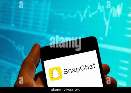 Chine. 19th févr. 2023. Dans cette illustration, le logo Snapchat de la messagerie multimédia s'affiche sur un smartphone avec un graphique d'indice boursier économique en arrière-plan. Crédit : SOPA Images Limited/Alamy Live News Banque D'Images