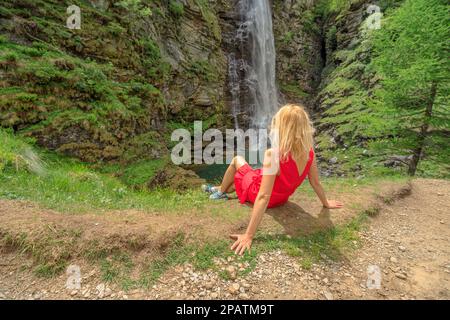 Petite fille de randonnée dans la forêt de Sonogno se reposant à la chute d'eau de la Froda près de la rivière Riale Carded. Ville de Sonogno en Suisse dans la vallée de Verzasca Banque D'Images