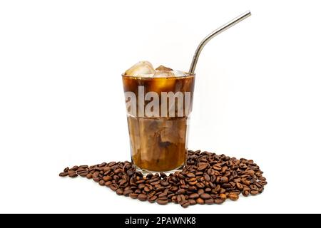 Café glacé et lait dans un verre transparent avec paille en inox métallique et grains de café isolés sur fond blanc Banque D'Images