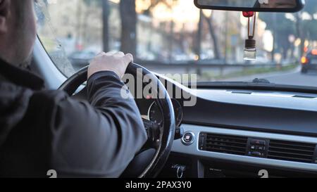 Photo générique d'un homme conduisant une voiture par un léger virage. Banque D'Images