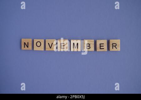 Le nom du mois de novembre est écrit sur des cubes en bois isolés. Vue de dessus des blocs de bois avec des lettres Banque D'Images