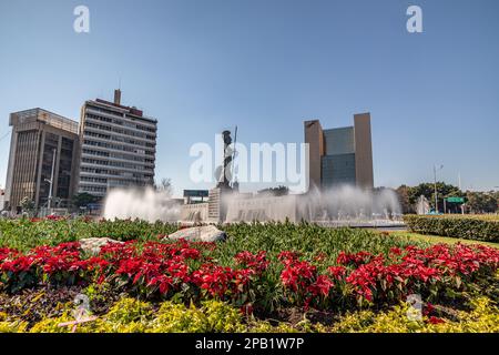 Guadalajara, Jalisco Mexique. 8 janvier 2023, Glorieta Minerva, statue de la déesse romaine dans la fontaine entourée de fleurs de poinsettia contre le bleu Banque D'Images