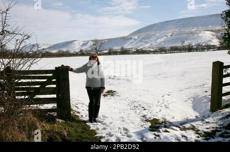 Une dame de haut niveau qui profite du soleil d'hiver sur Pendle Hill, Lancashire, Royaume-Uni, Europe Banque D'Images